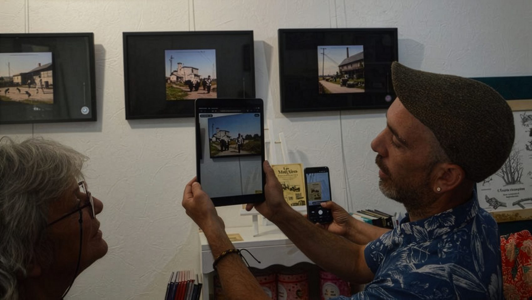 Visiteurs découvrant une œuvre animée sur tablette devant les cadres
